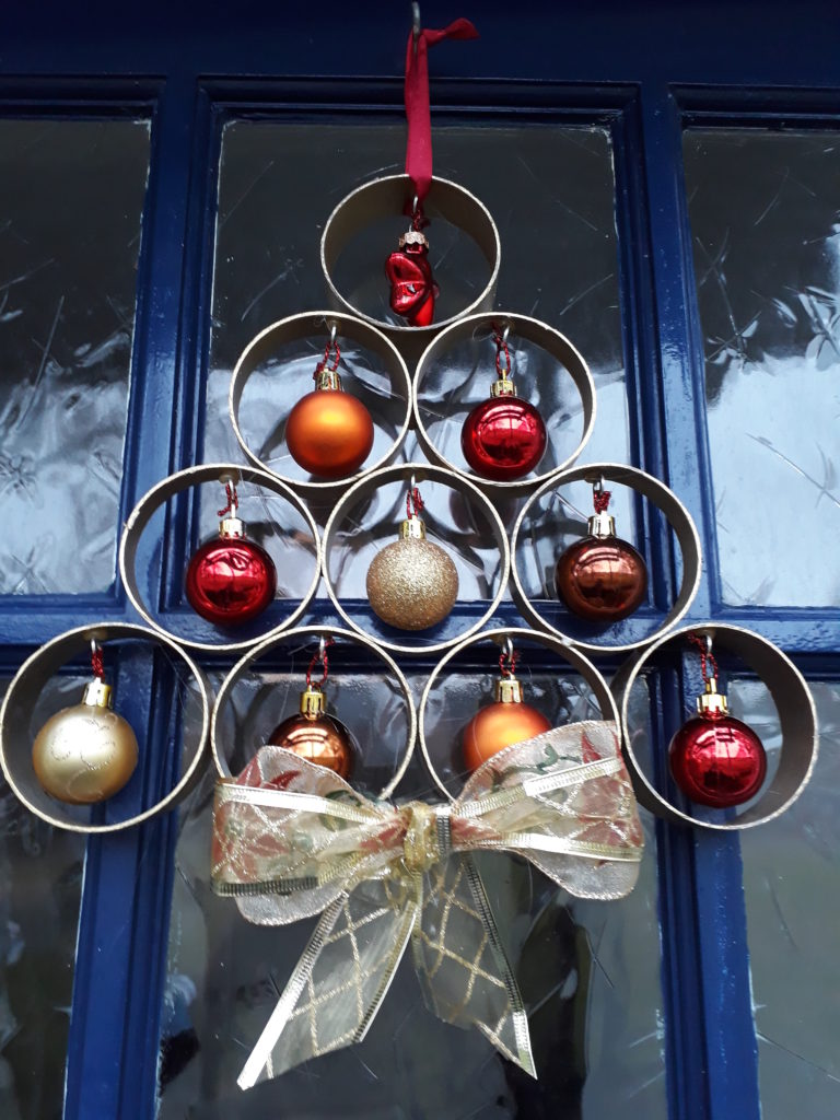 Een kerstboom aan je deur van pvc buis geeft fleur aan je huis